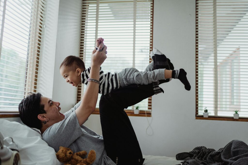 Dad and son enjoying playtime indoors. Joyful bonding moment.